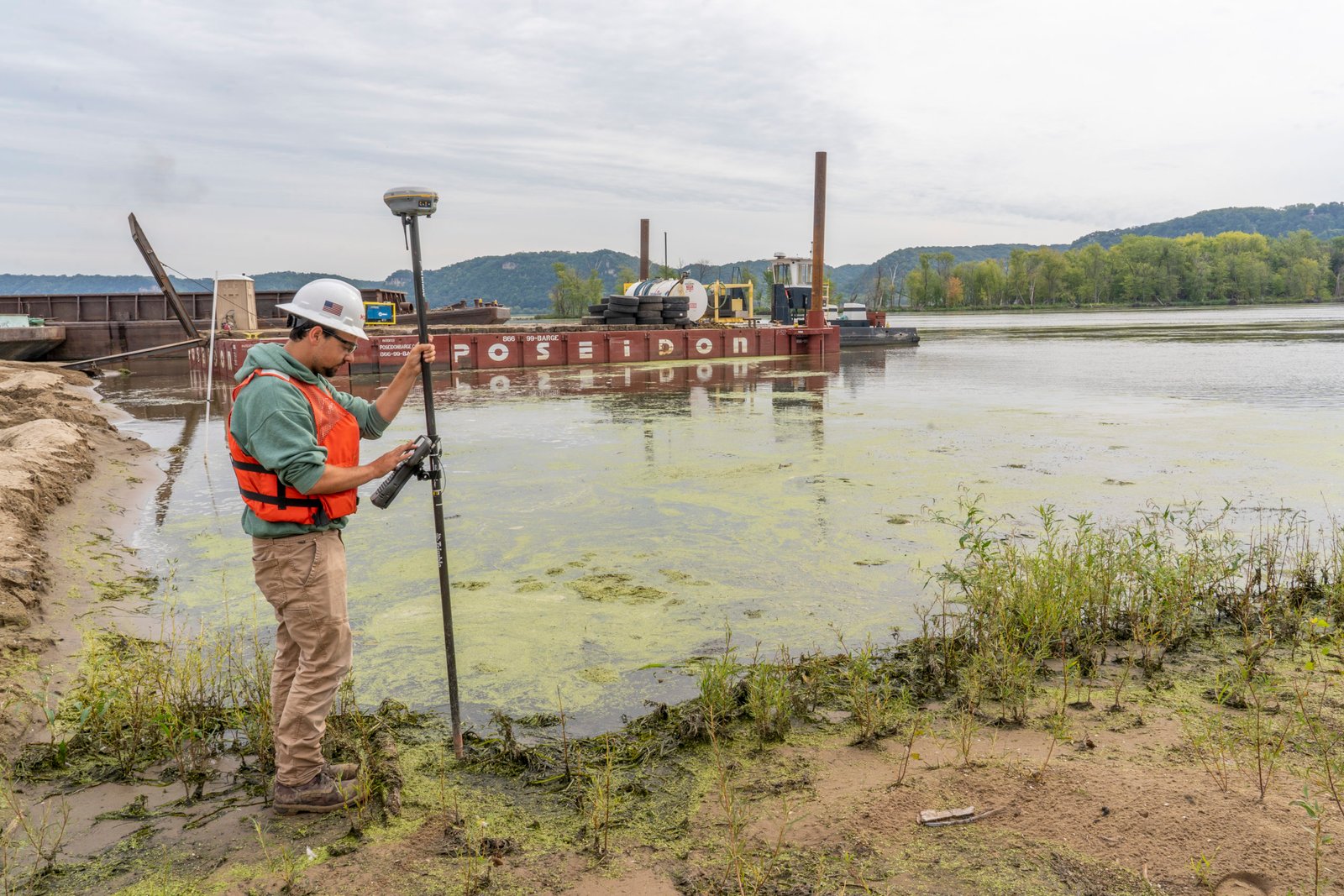 A worker works at the edge of the Upper Mississppi River.
