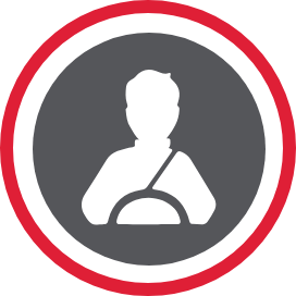 A person behind the while with their seatbelt on.
